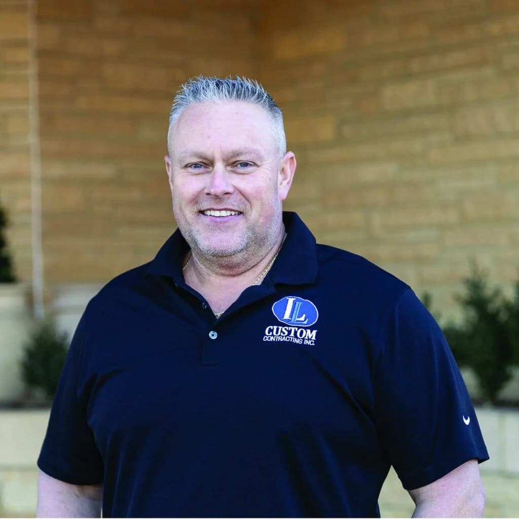 Smiling man with short grey hair wearing a navy IL Custom Contracting polo shirt.